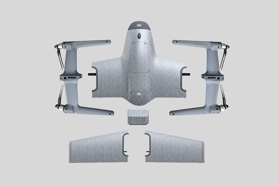 All the parts of HEQ SWan K1 Pro UAV VTOL platform with wings, arms, weight block and body on a grey background